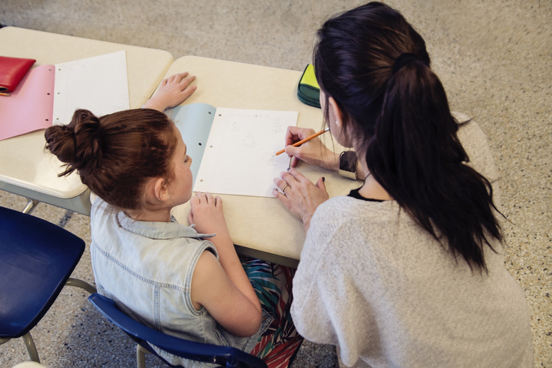 Teacher helping elementary student after class.