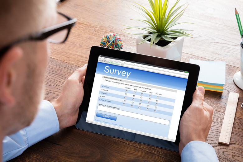 Person Filling Online Survey Form On Digital Tablet