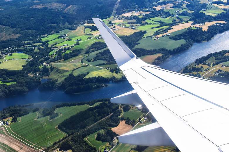 wing of a commercial plane against rural landscape