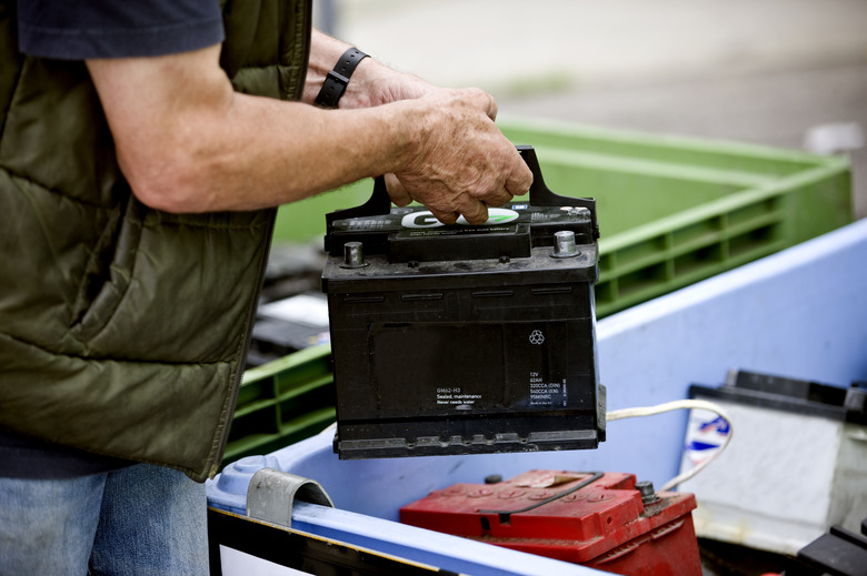 Senior man recycling a car battery