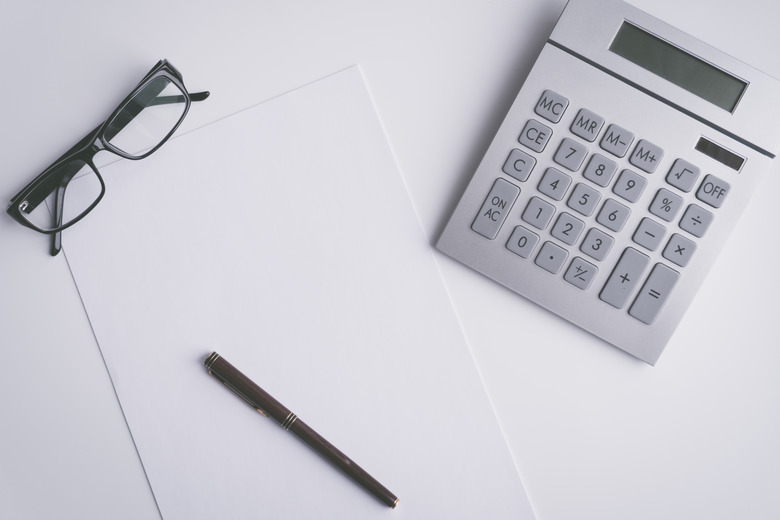 High Angle View Of Calculator With Paper And Pen On Table