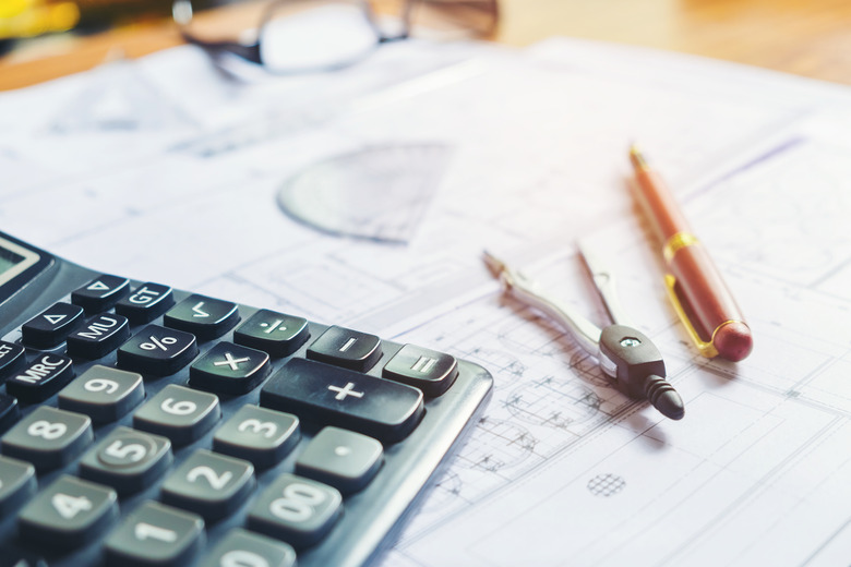 High Angle View Of Calculator With Blueprints And Pen On Table