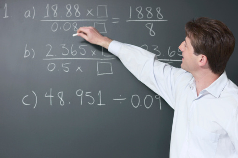 Man writing equations on a chalkboard