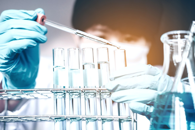 scientist dropping chemical liquid to flask in lab Glass laboratory chemical test,Laboratory research concept