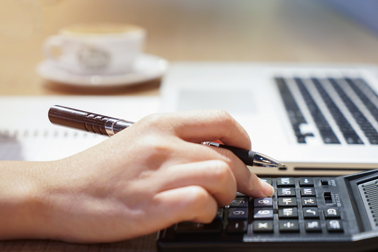 Woman hand working with calculator, business document and laptop computer notebook,