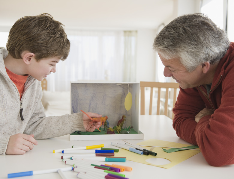 Father and son working on dinosaur project