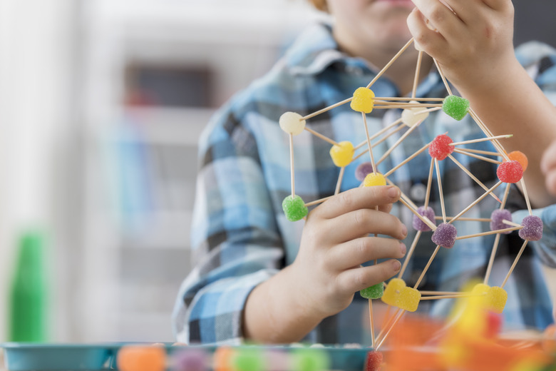 Boy creates something from toothpicks and gum drop candy