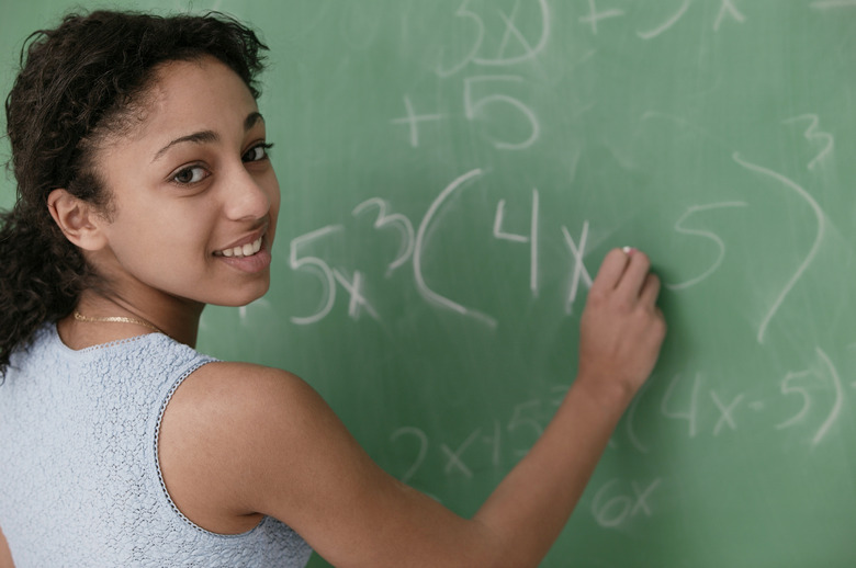 Teenage girl writing on chalkboard