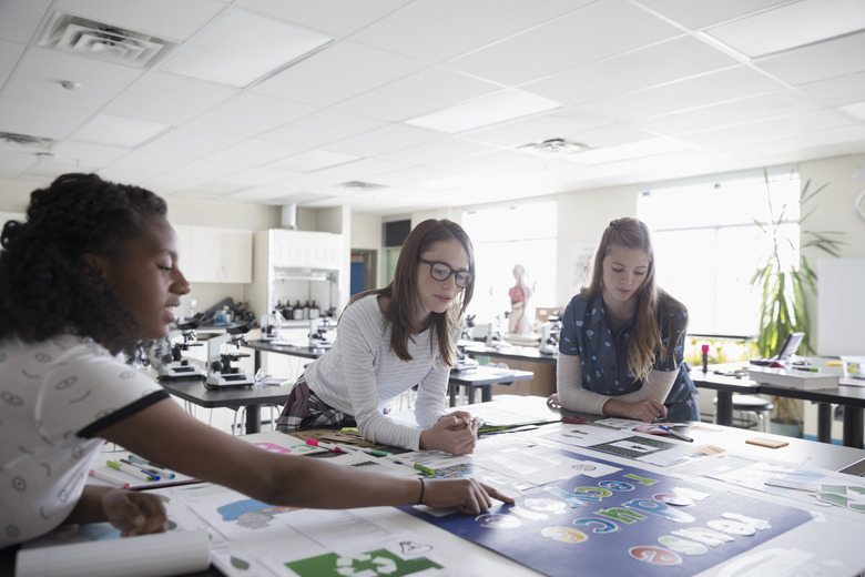 Girl middle school students working on science project in classroom