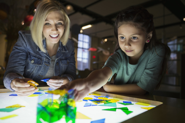 Mother daughter assembling geometric shapes at science center