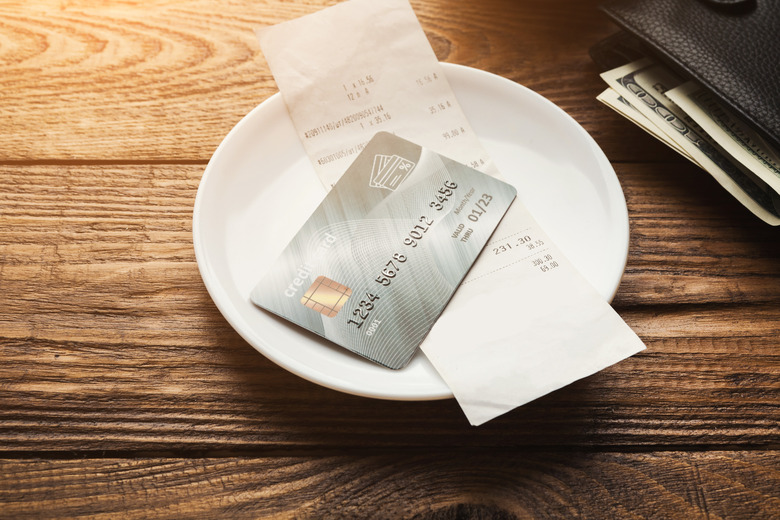 Restaurant bill and credit card on wooden table