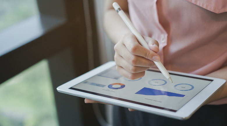 close up on businesswoman manager hand using stylus pen for writing or comment on screen dashboard tablet in meeting situation about company's performance , technology and business strategy concept