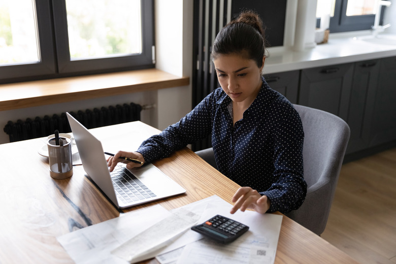 Busy millennial indian woman professional accountant preparing annual financial report