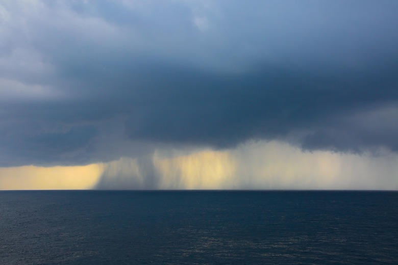 Rain & storms over the ocean, on a grey cloud day at sea.