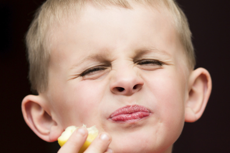 Young boy eating a lemon