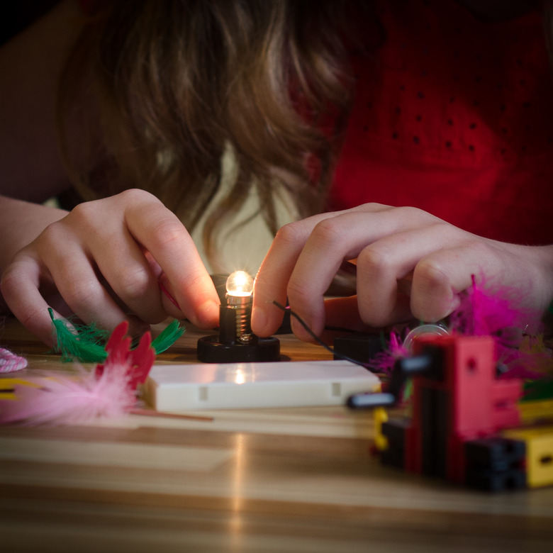 Girl Connect Lightbulb with a battery