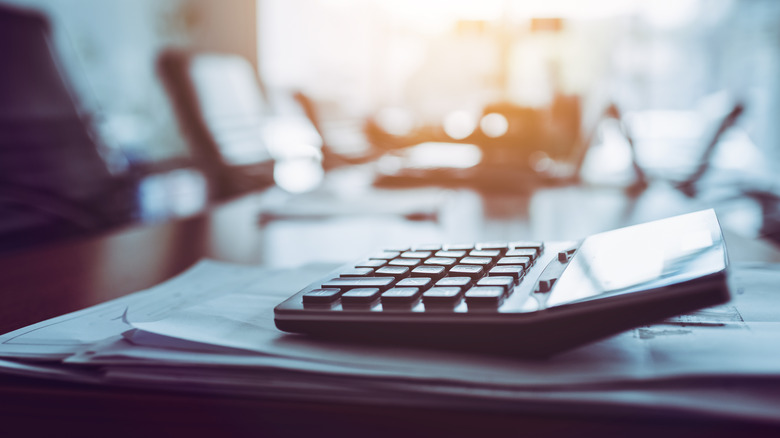 Close up calculator on business working desk, dark background.