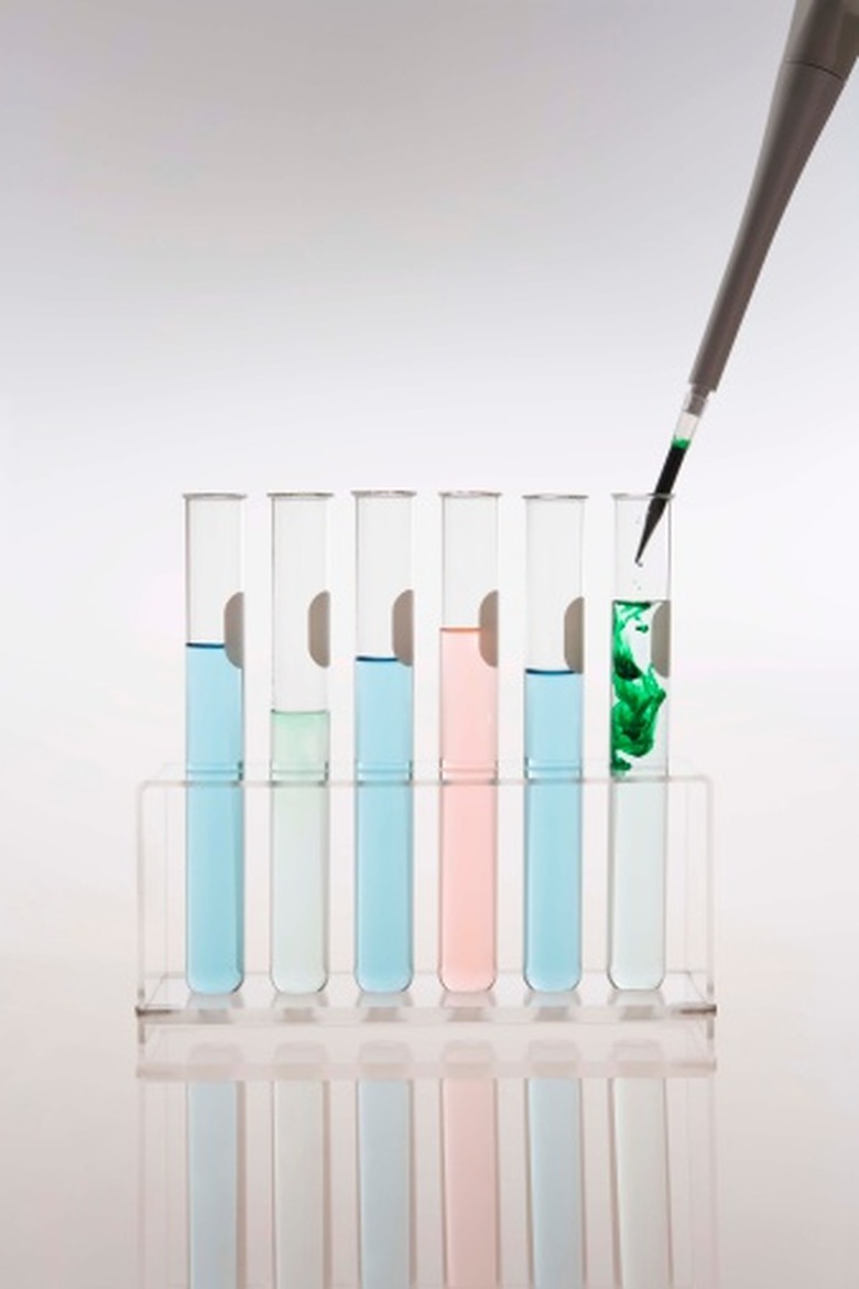 A pipette dropping green liquid into a test tube