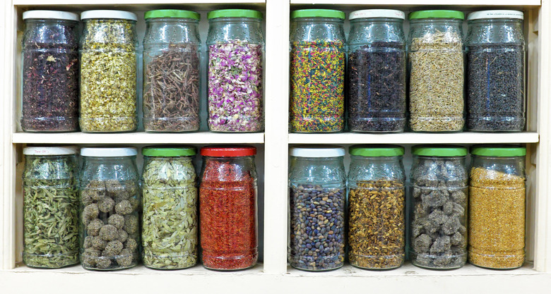 Assortment of glass jars on shelves in herbalist shop Morocco