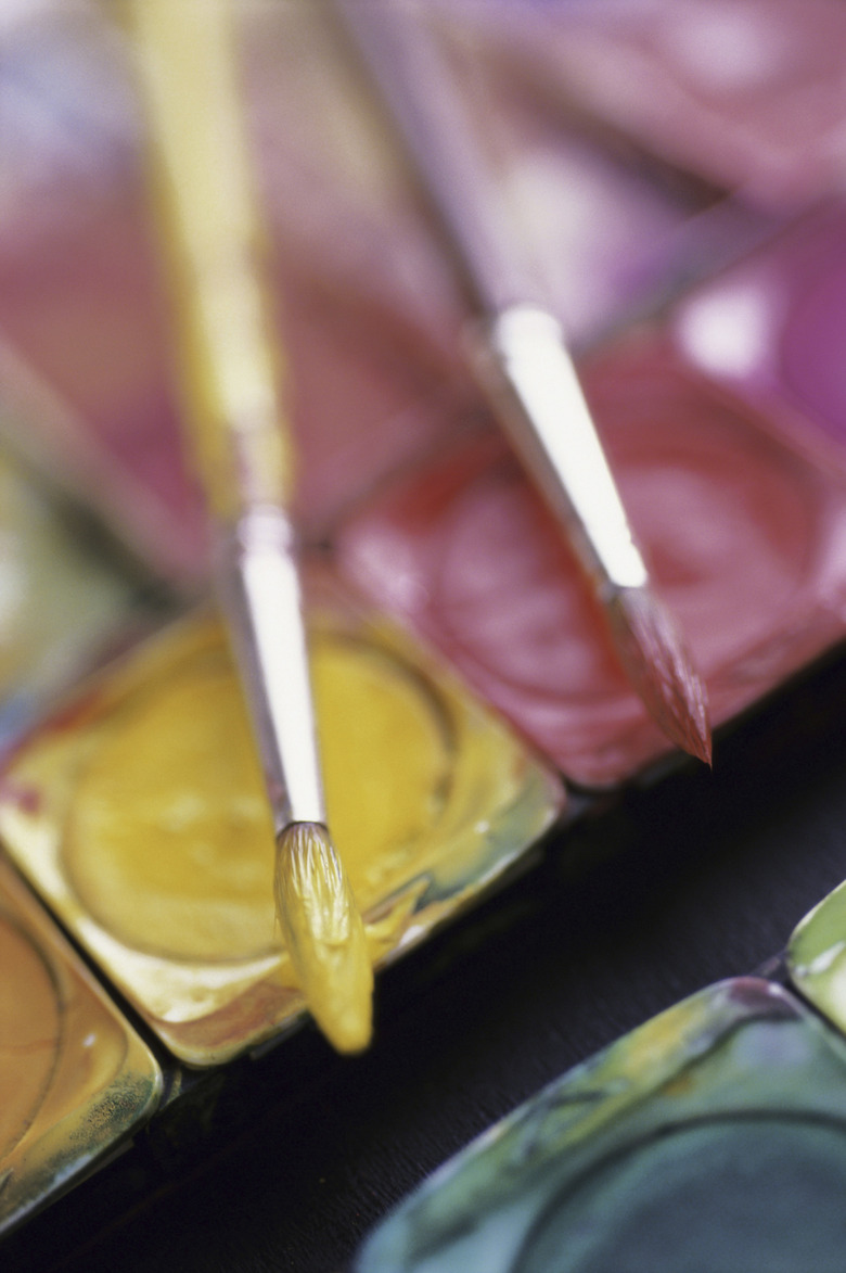 Close-up of paintbrushes on watercolors