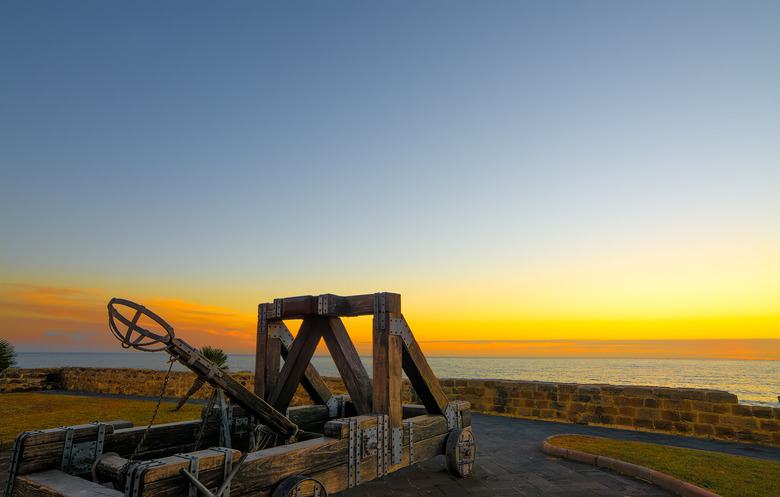 antique catapult by Alghero promenade at sunset