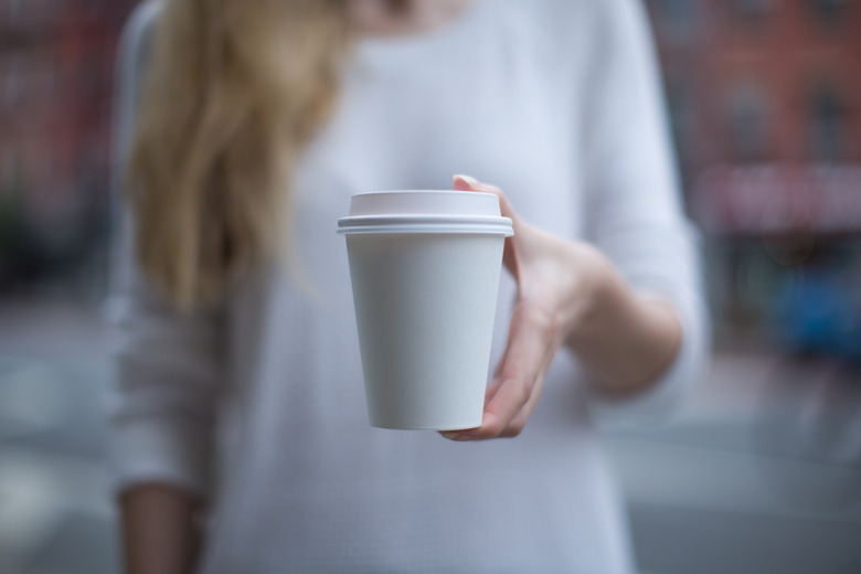 Women hand holding paper cup