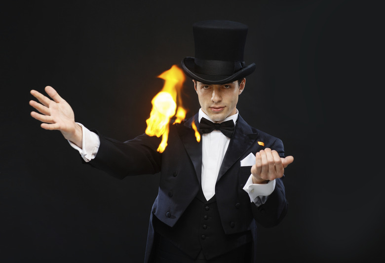 magician in top hat showing trick with fire