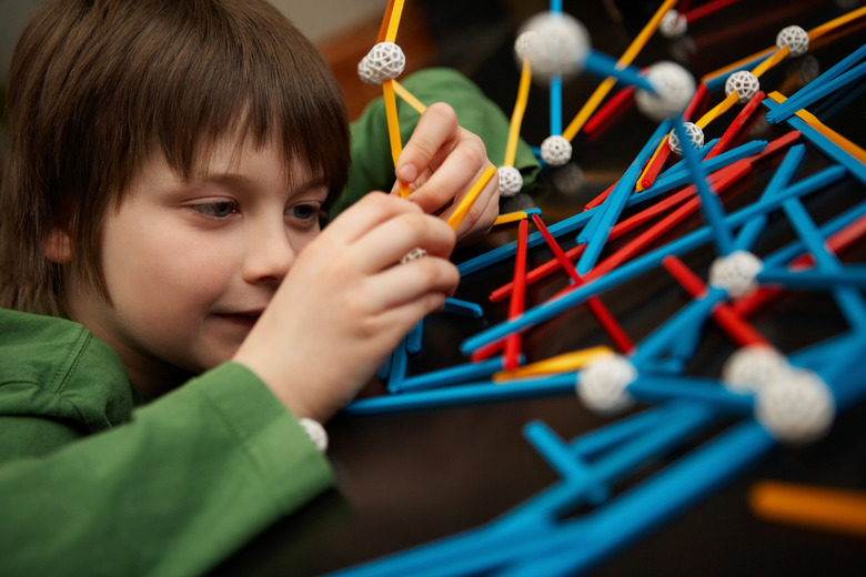 Boy connecting molecules for science project