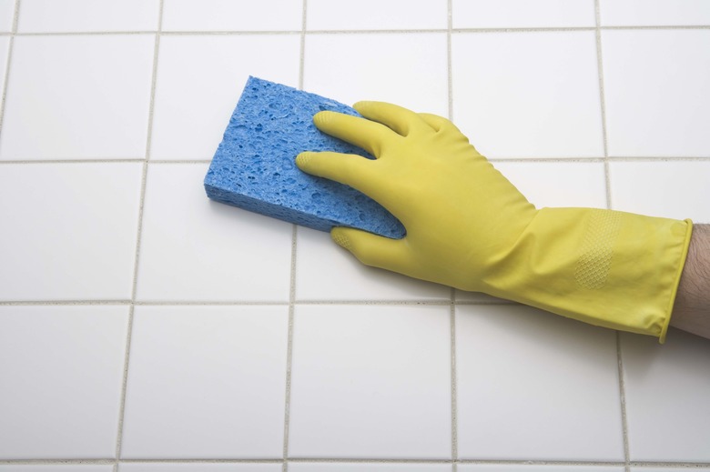 Person using sponge to clean tile