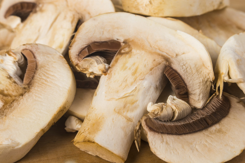 Delicious raw Agraicus mushrooms on wooden background