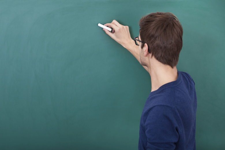 Male Student Writing On Chalkboard