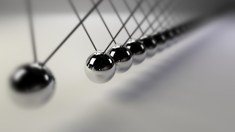 cause and effect concept, infinity steel Newton's cradle on a white background (3d illustration with dof)