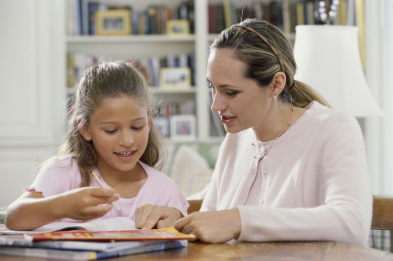 Mother assisting her daughter with her homework