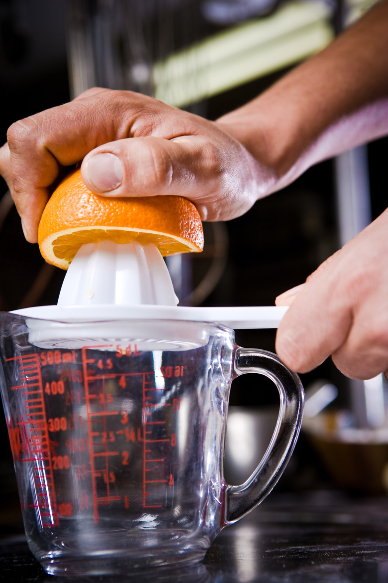 Cook squeezing orange juice manually