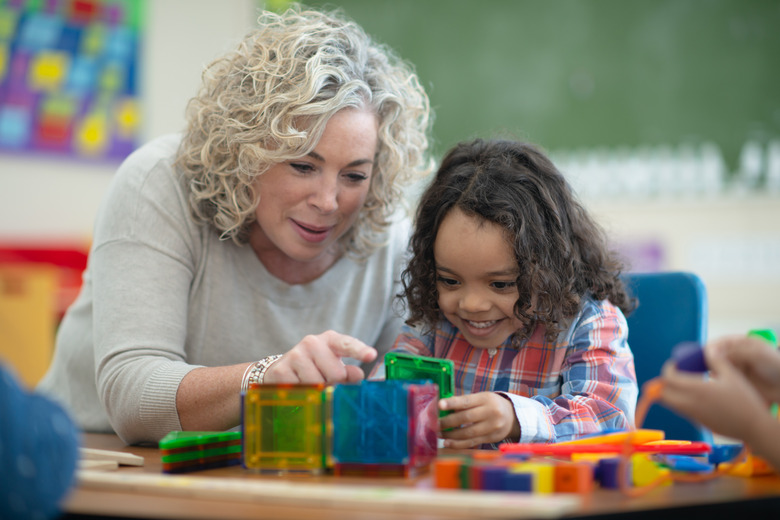 teacher and student play with magnetic blocks