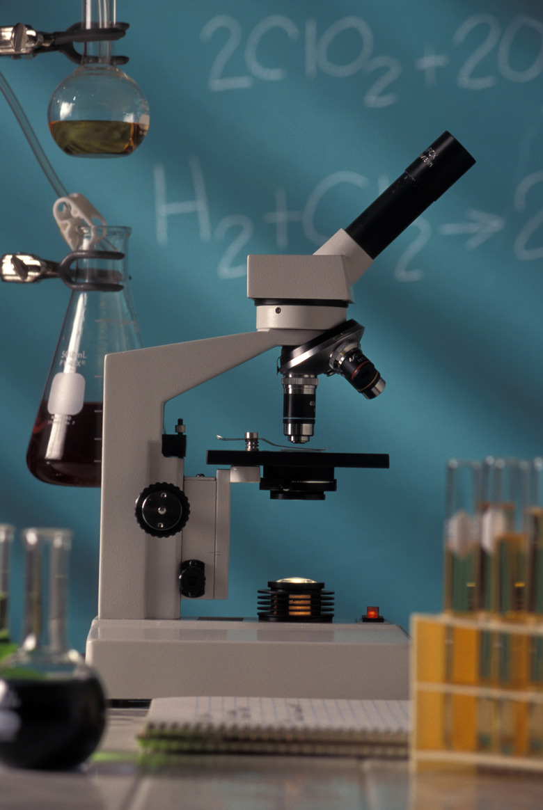 Microscope And Beakers Sitting On Table In Science Classroom