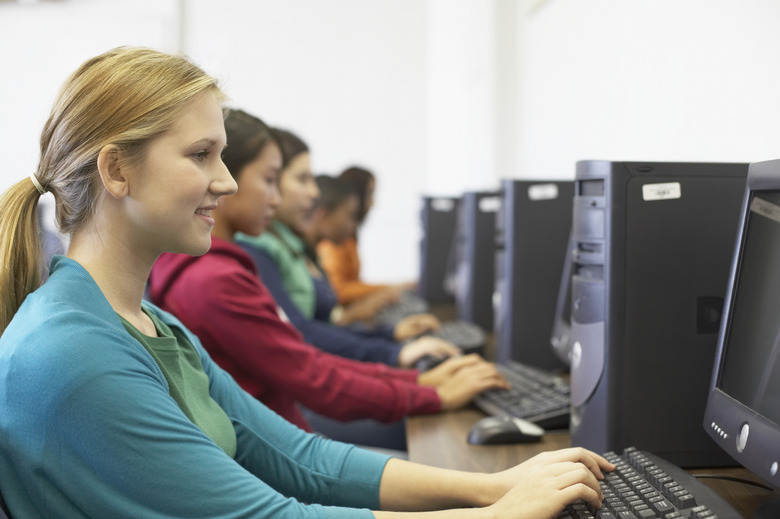 Side profile of a group of teenagers in front of computer monitors