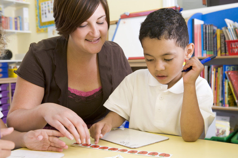 Primary school teacher helping boy with maths