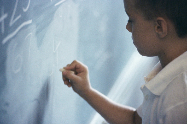 Boy writing on a chalkboard