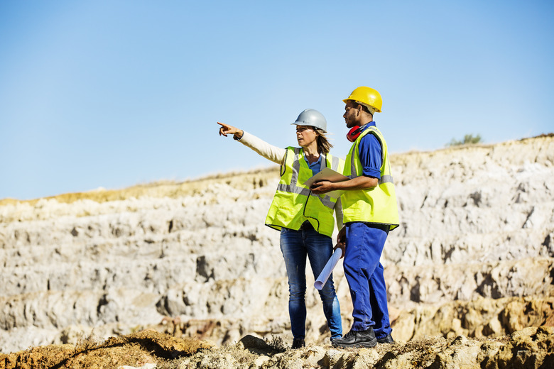 Architect explaining plan to quarry worker at site