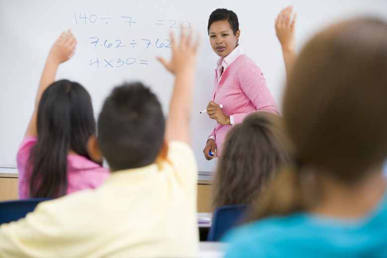 Students in class volunteering for teacher at front board (selective focus)