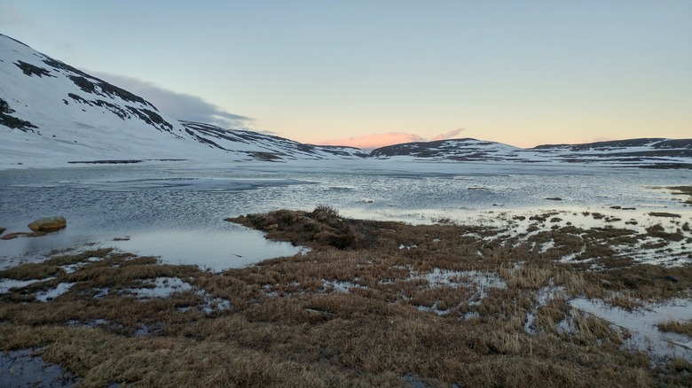 Scenic View Of Snowcapped Mountains And Lake Against Sky During Sunset