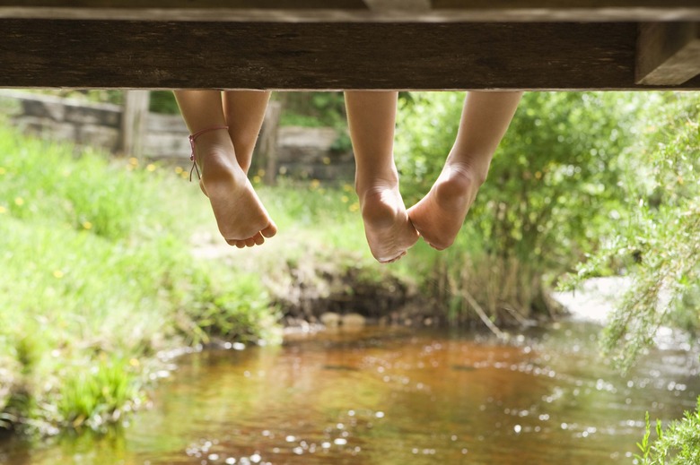 Feet of children dangling over stream