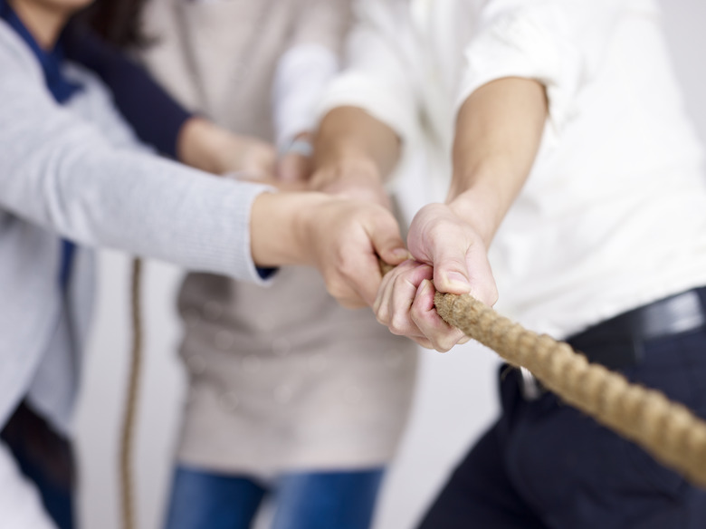 group of business people playing tug-of-war