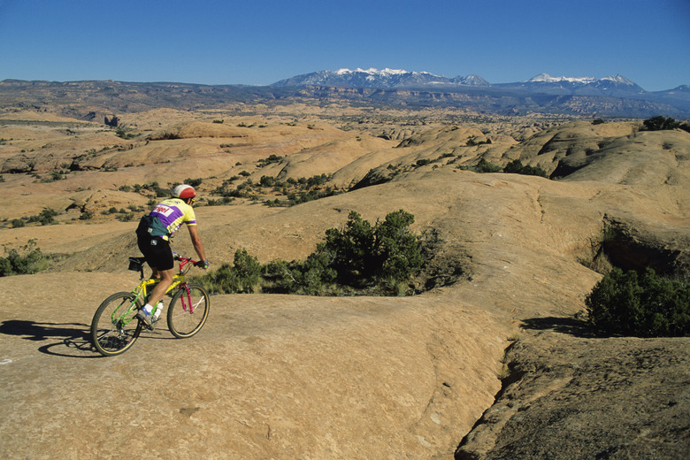 Mountain biker on rock trail. Moab, Utah, USA