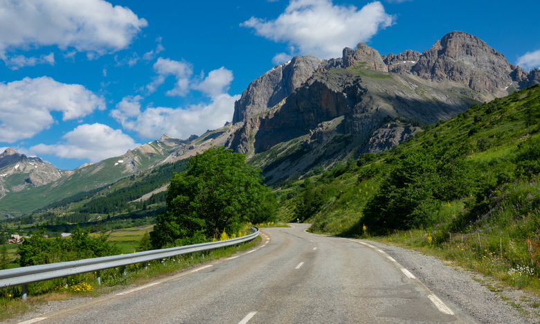 Spectacular nature surrounds the empty asphalt road in the French countryside.