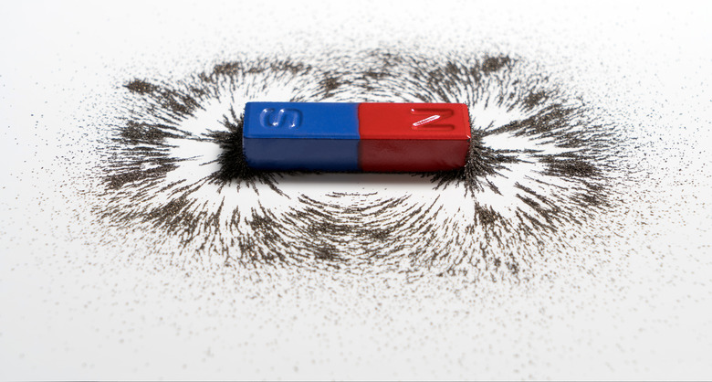 Red and blue bar magnet or physics magnetic with iron powder magnetic field on white background.