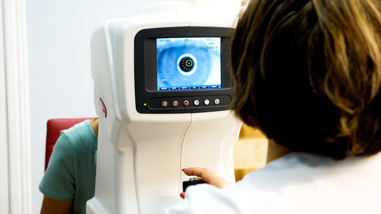 Optician doctor working with the refractometer machine.