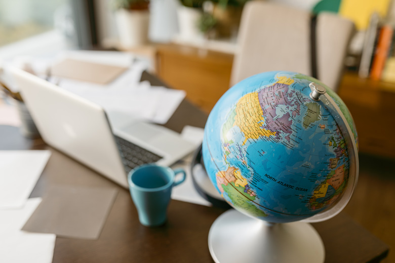 Globe with laptop and mug on table