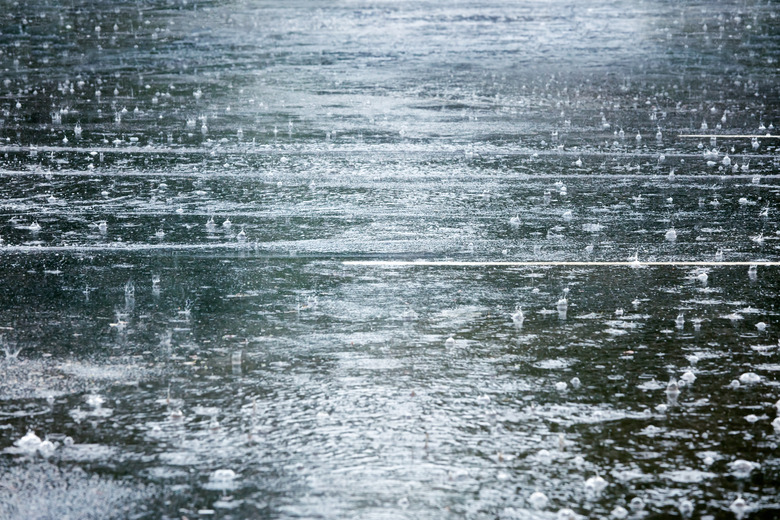 flooded road during heavy rain with raindrops splashes